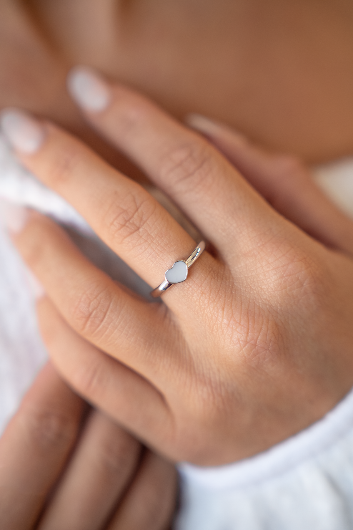 Silberner Ring mit herzförmigem Kunstharz aus Muttermilch, zarte Fassung und feine Details.